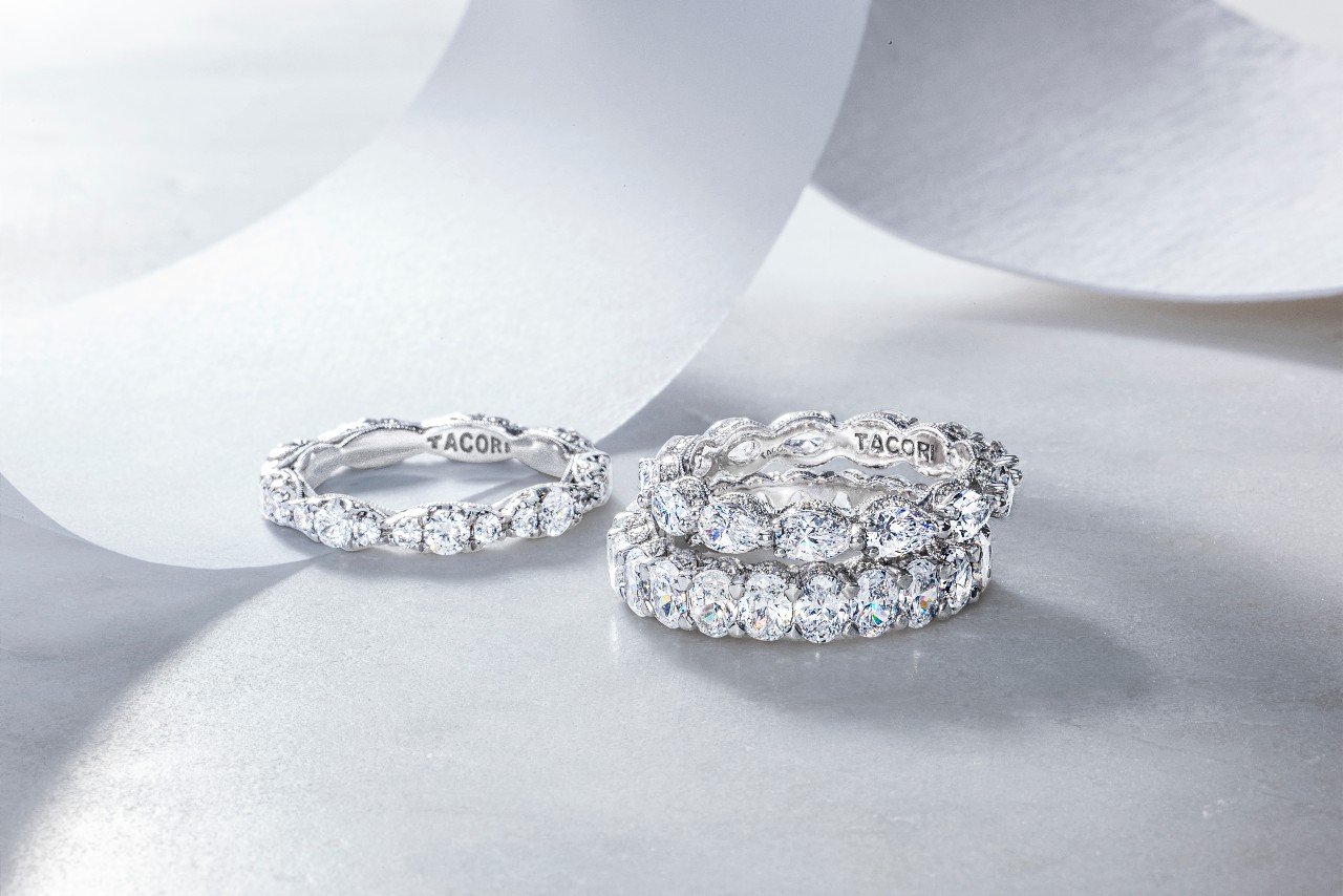 three diamond wedding bands by TACORI stacked on a white surface