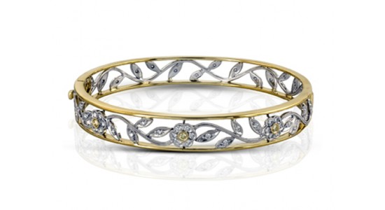 a mixed metal bangle bracelet featuring flower and vine motifs