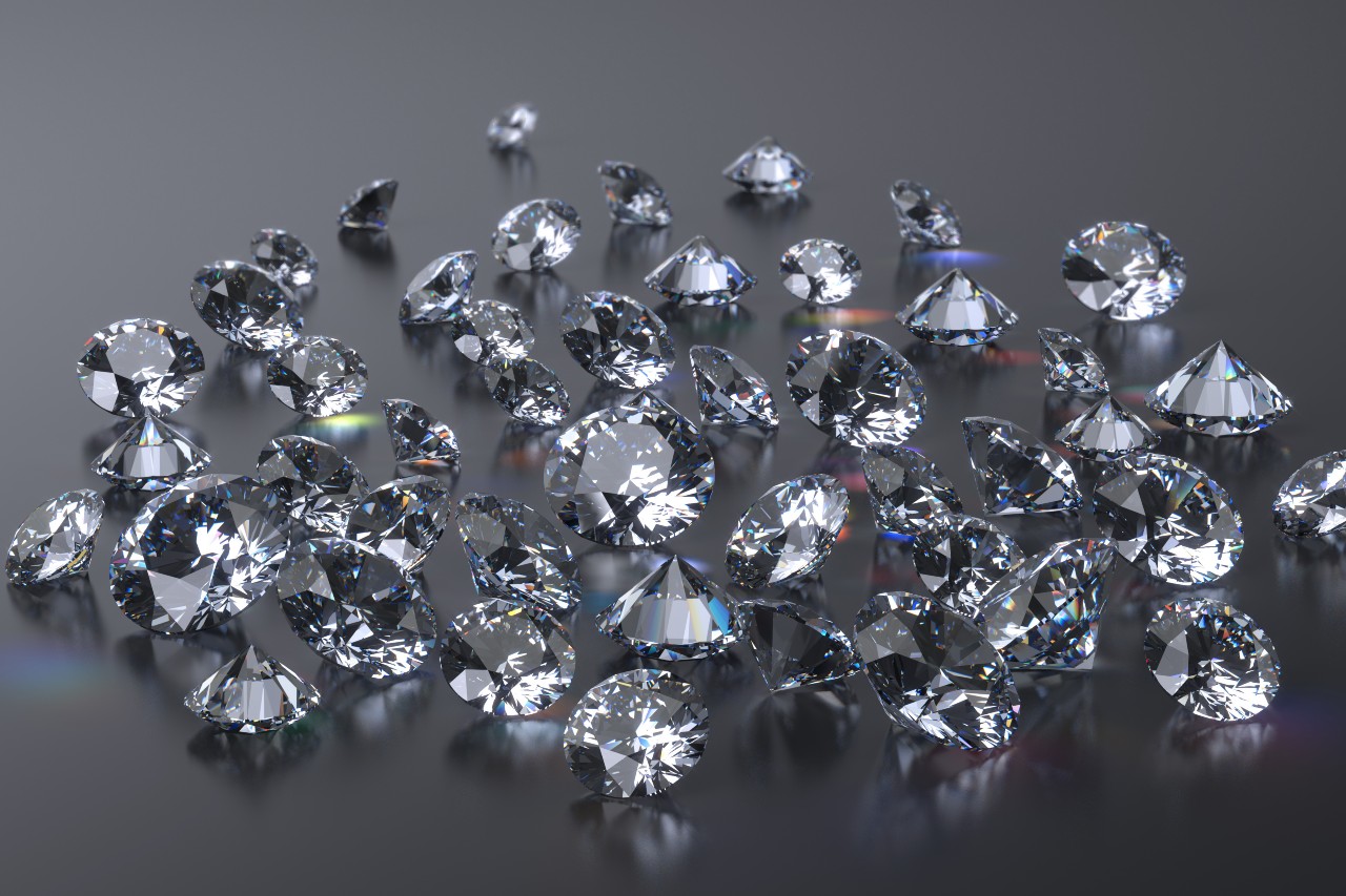 A cluster of round cut diamonds on a dark, reflective surface.