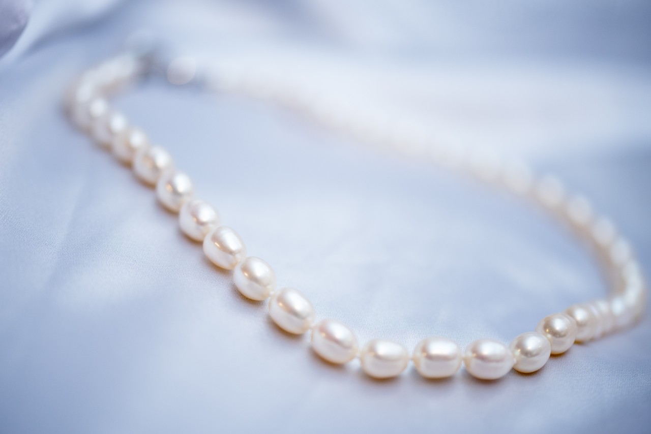 A close-up of a simple yet elegant pearl necklace.